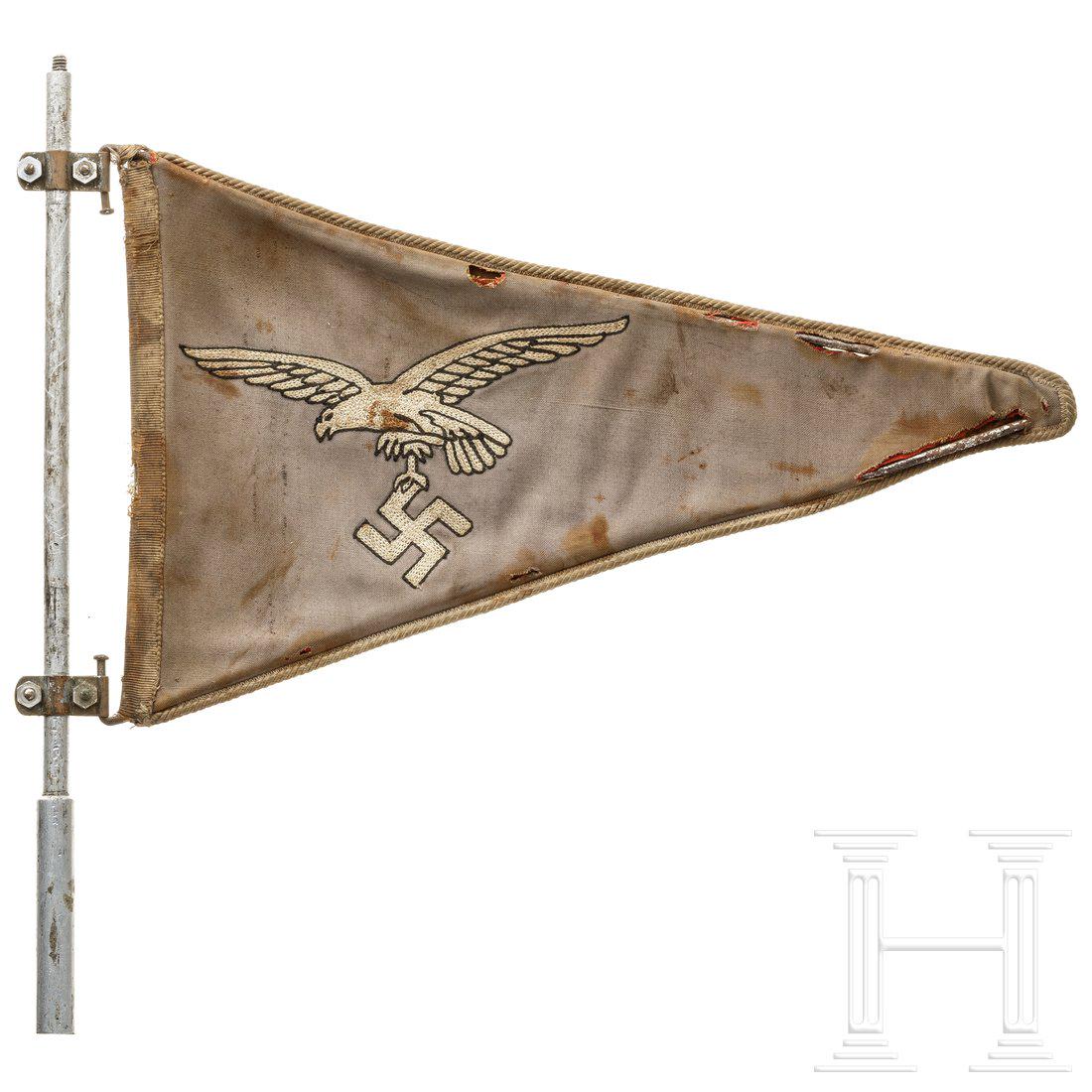 A car pennant for officers of the Luftwaffe (air force): Luftwaffenblauer Dreieckswimpel mit beidseitig hellgrau eingesticktem Luftwaffenadler und hellgrauer Einfassungskordel an den LÃ¤ngsseiten. Der innenseitige VerstÃ¤rkungsrahmen beweglich mit der B