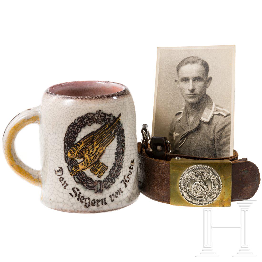 A large collection of objects from World War II, with: Fayence-Krug, farbig gestaltet, ½-Liter, vs. FallschirmschÃ¼tzen-Abzeichen und Sinnspruch, unten Nummer â€ž4922â€œ, HÃ¶he 12 cm, dazu orig. Portrait-Foto des beliehenen Fallschirmj�