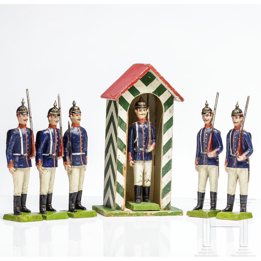 Six Prussian Elastolin Soldiers in 18 cm size with a: Sechs preuÃŸische Soldaten, Elastolin/ungemarkt, ca. 1908, 18 cm-Serie, dabei ein Offizier den Degen gezogen, vier Marschierer mit Tornister und Gewehr und ein solcher Soldat im passenden Schilderha