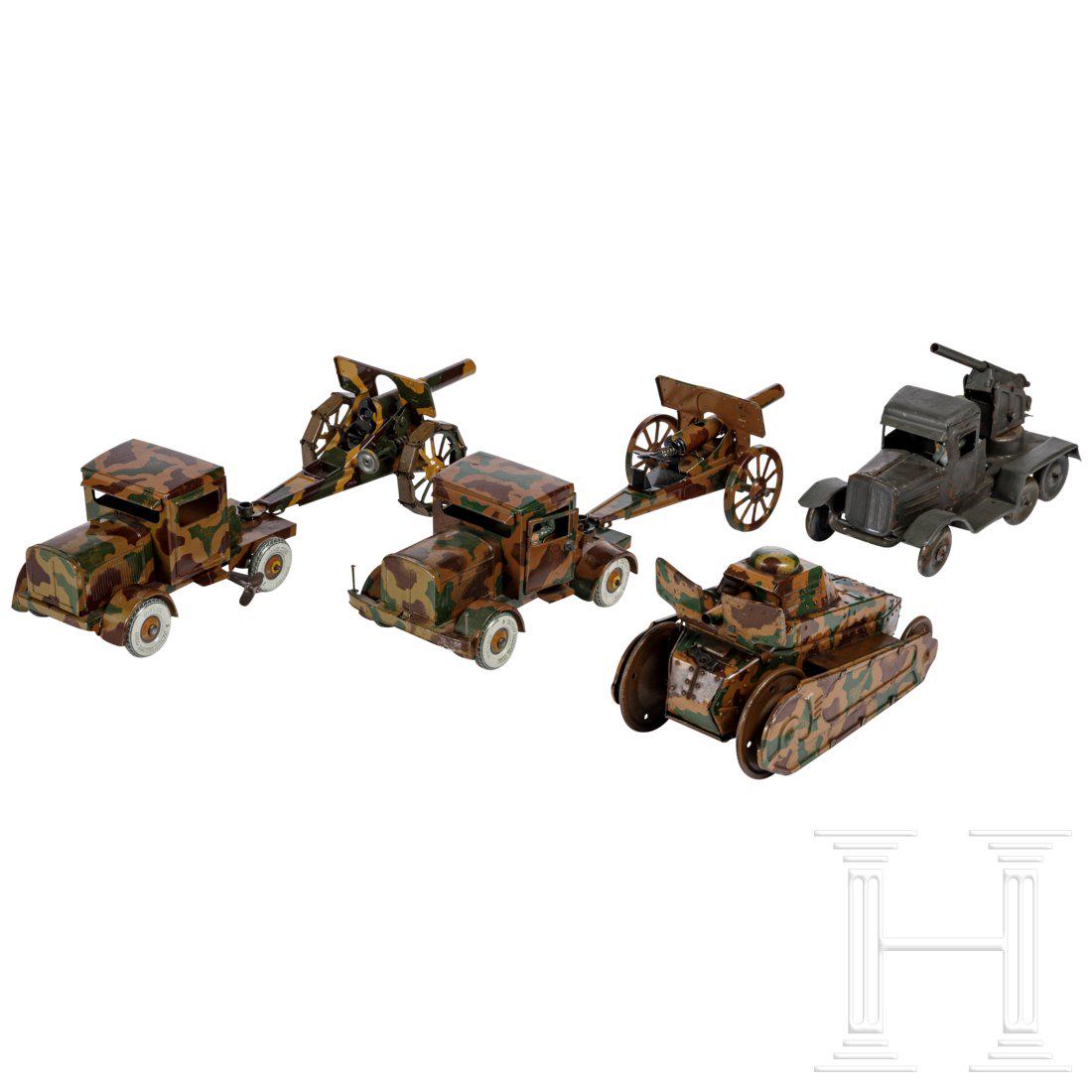 Four TippCo and Goeso military toy vehicles with Flak: Vier MilitÃ¤rfahrzeuge TippCo/GÃ¶so, 30er Jahre, 6/7 cm-Serie, BlechausfÃ¼hrung; dabei ein Klettertank, mimikry, Uhrwerk lÃ¤uft, Gummiketten ersetzt/lose anbei; ein Zugwagen, mimikry, Uhrwerk 