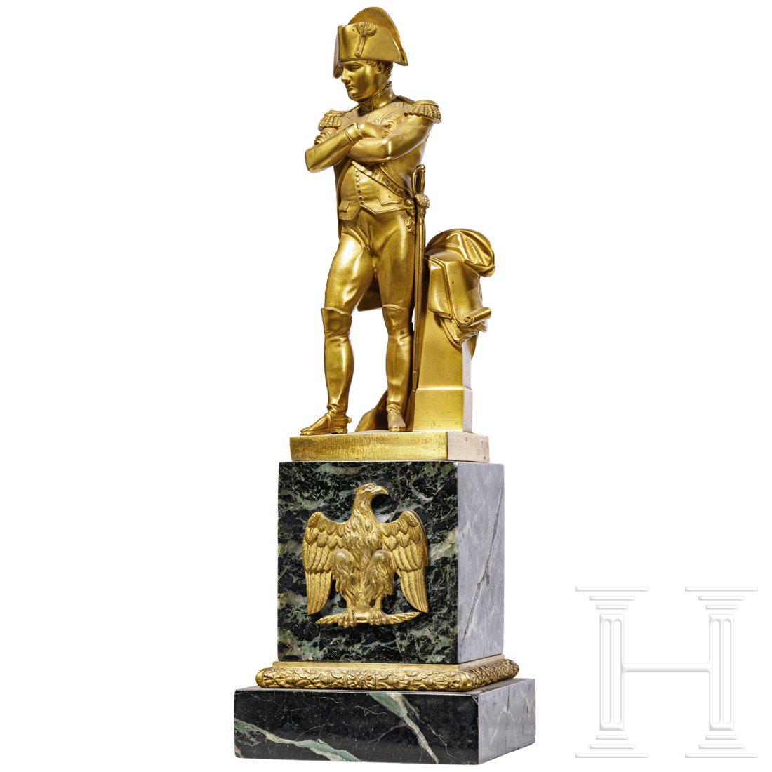 A French brass statuette of Napoleon Bonaparte, 19th: A French brass statuette of Napoleon Bonaparte, 19th centuryVergoldetes Messing. Bonaparte in seiner typischen Uniform an einer Stele lehnend, Ã¼ber die er seinen Mantel geworfen hat. Quadratische P