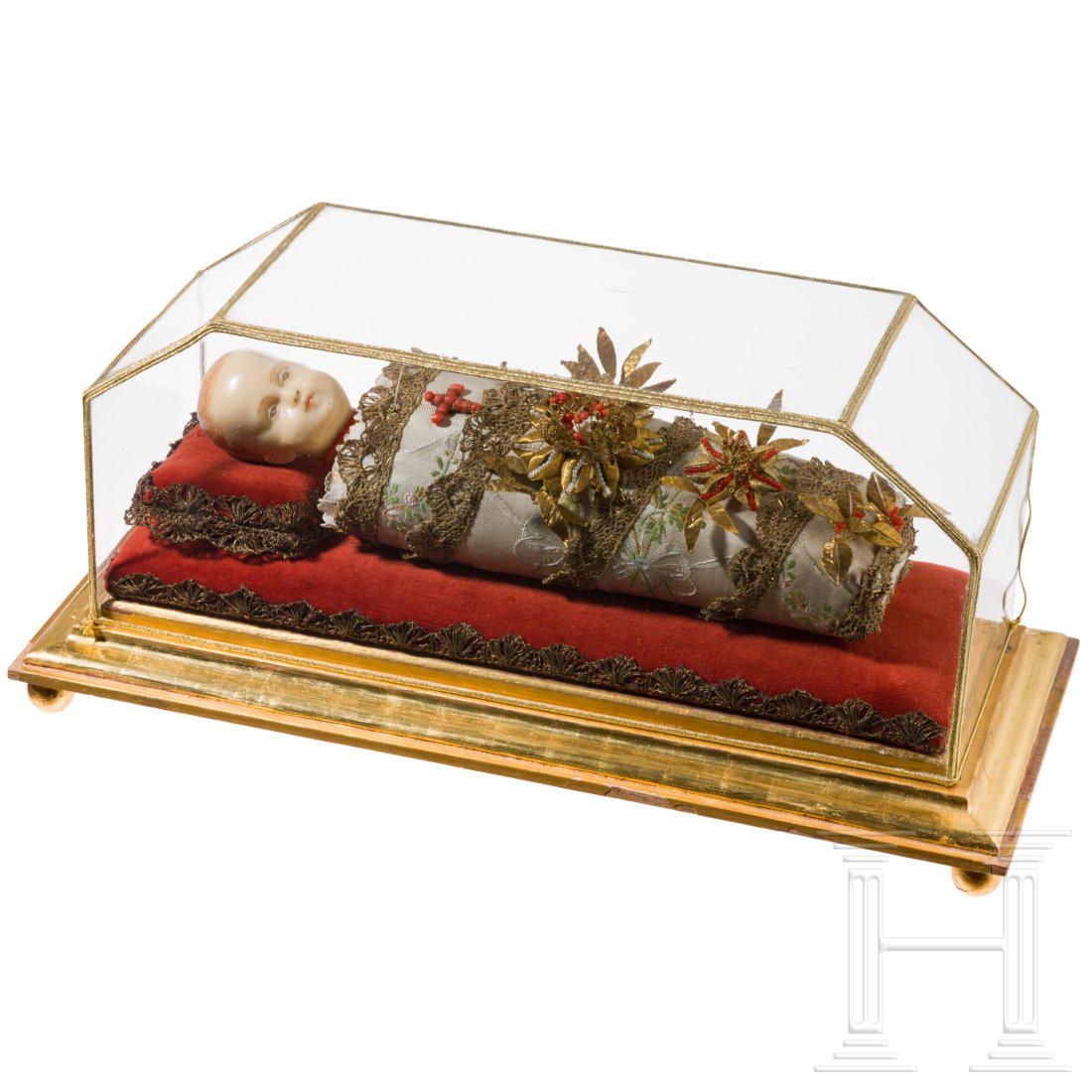 A South German swaddled baby with wax head in showcase,: A South German swaddled baby with wax head in showcase, 19th centuryFully sculptured. Finely wrapped Christ child with partly painted wax head, richly decorated, partly in red coral and partly gilded.