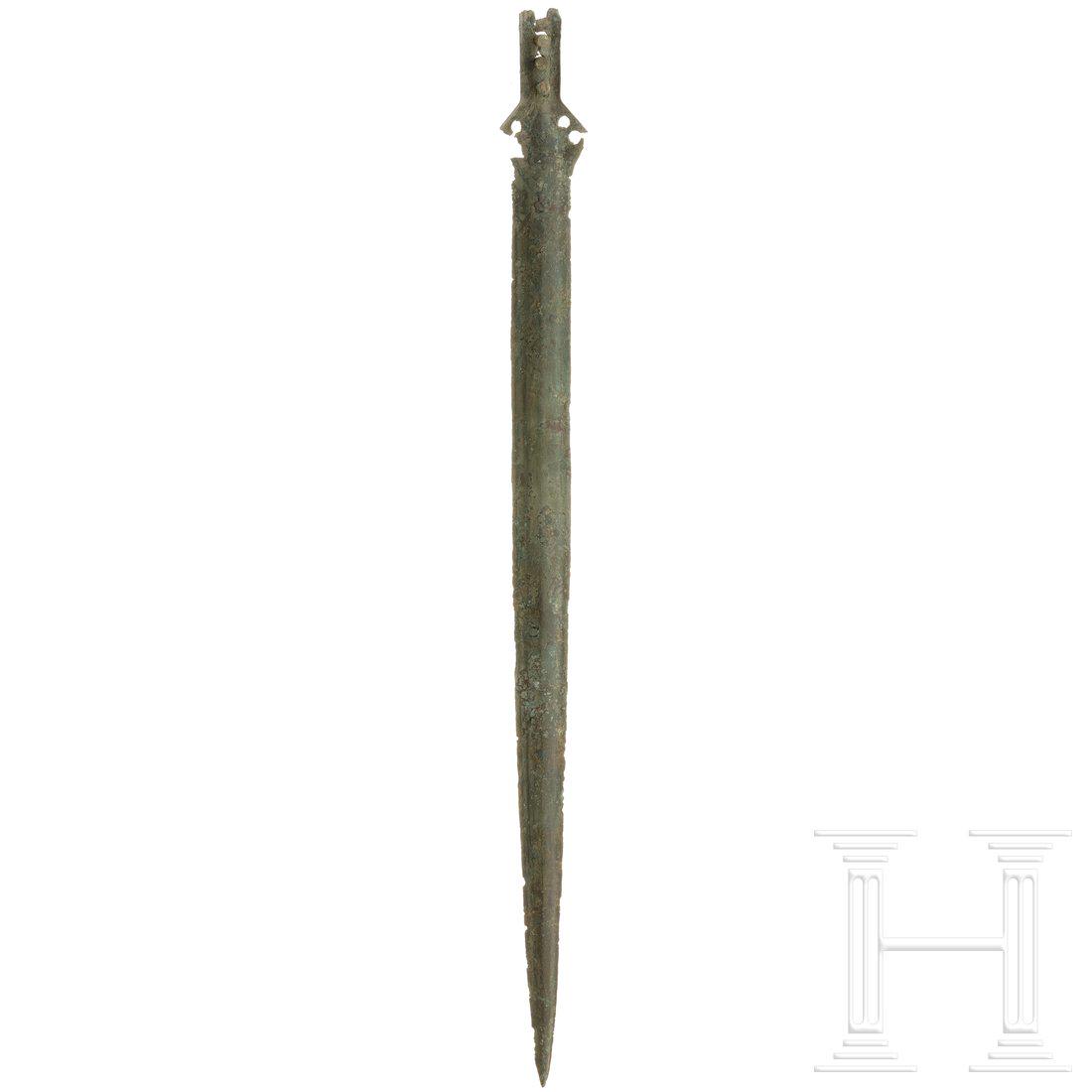 A sword, Bronze Age, 12th century B.C.: A sword, Bronze Age, 12th century B.C.Long narrow blade with a bulging centre rib. Minimal chipping on the cutting edges and chipping in the area of the hilt. Four rivet holes there, one loose rivet p