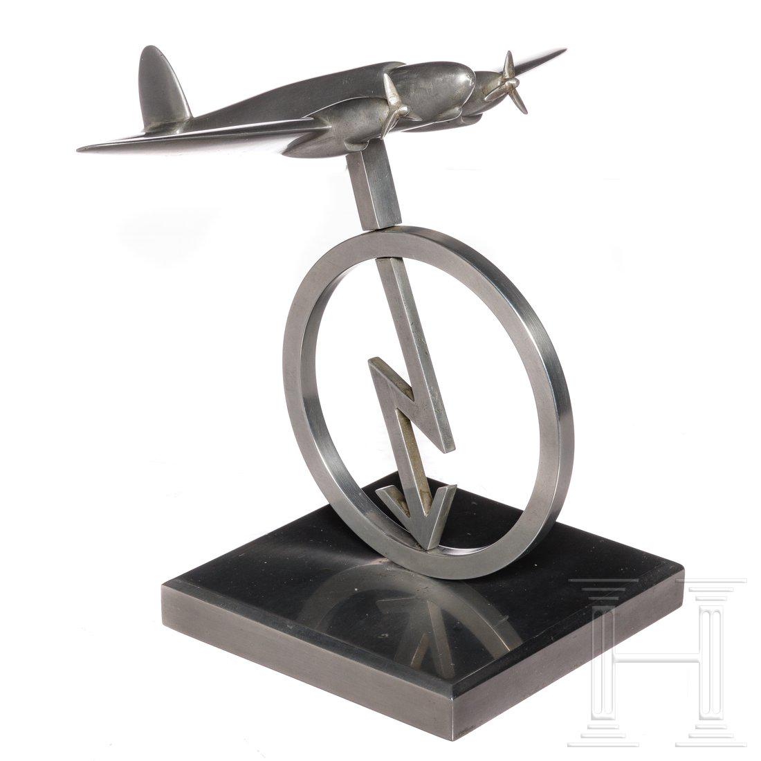 A model of a twin engine airplane: A model of a twin engine airplane Aluminiumguss, teils poliert, mit beweglichen Propellern. Der kreisrunde StÃ¤nder mit dem stilisierten Blitz der Luftnachrichtentruppe bzw. der Bordfunker. HÃ¶he 