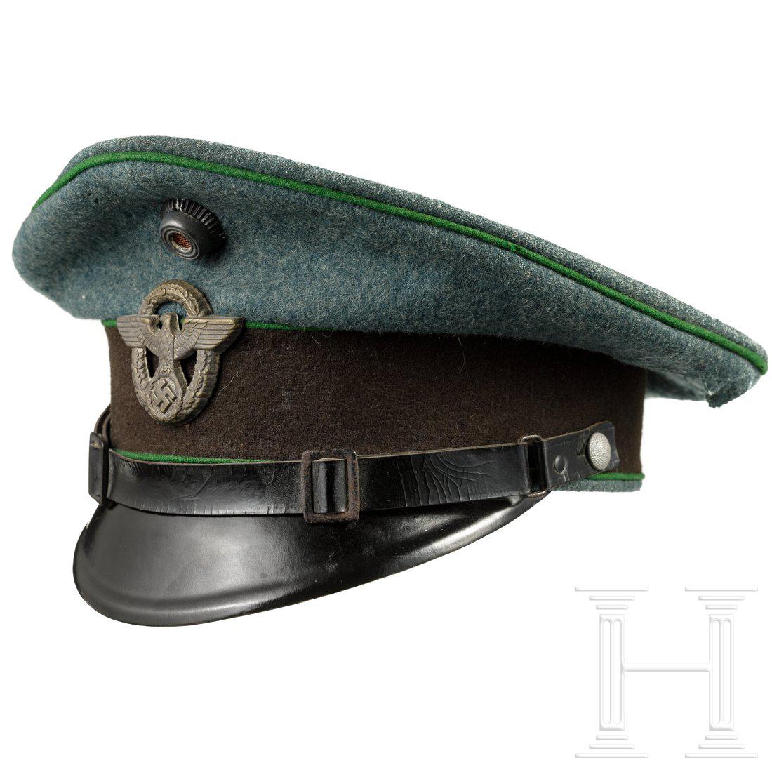 A visor hat for EM/NCO of the Schutzpolizei: A visor hat for EM/NCO of the SchutzpolizeiPolizeigrÃ¼ner Wollstoff (grÃ¶ÃŸere Fehlstellen) mit dunkelbraunem Besatzband und hellgrÃ¼nen VorstÃ¶ÃŸen, brÃ¤unliches Wachstuch-/Leinenfutter