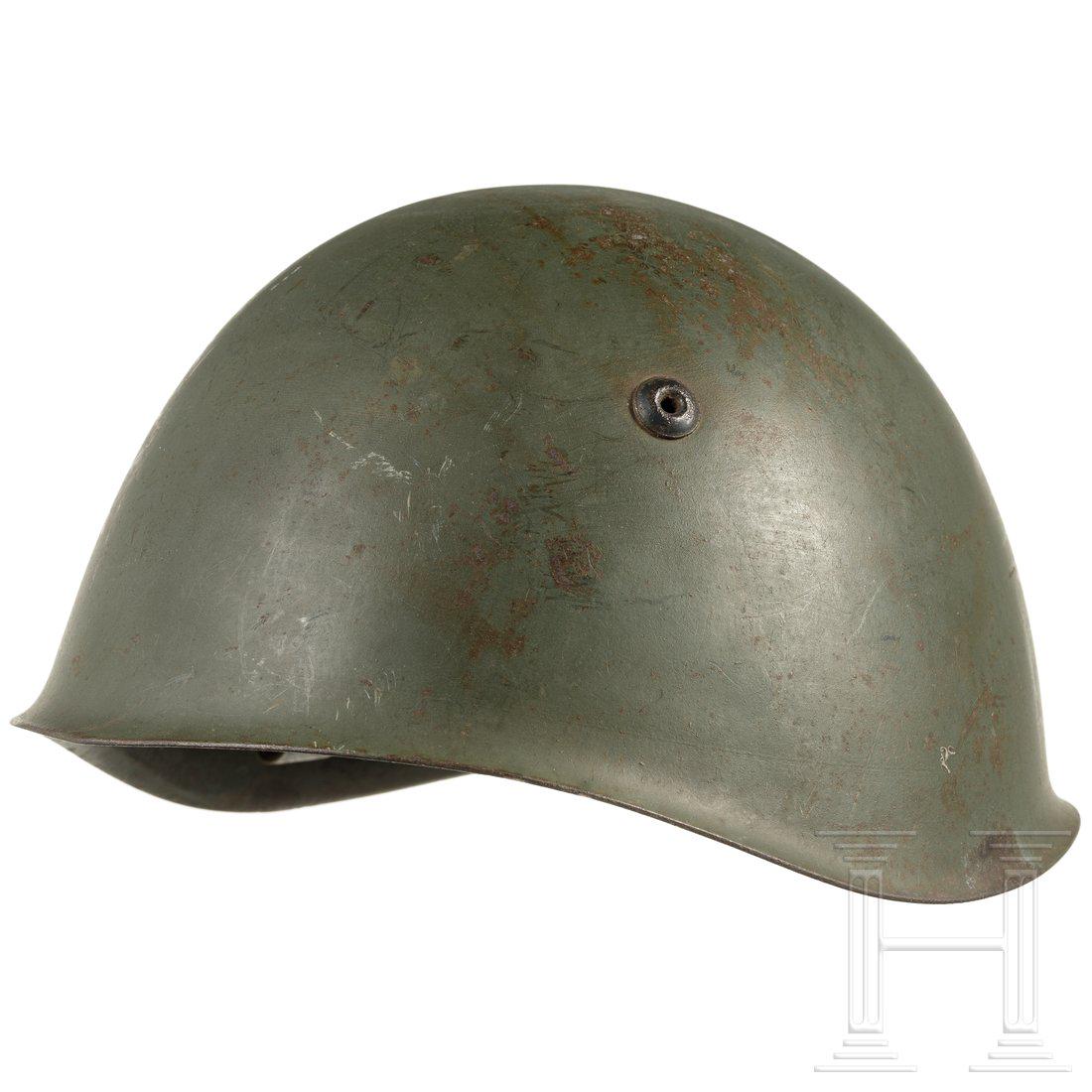An Italian steel helmet M 33, 1930s - 1940s: An Italian steel helmet M 33, 1930s - 1940sStahl, graugrÃ¼n lackiert (berieben, Rostspuren), innen gestempelt "BB 62", drei LÃ¼ftungsnieten. Braunes Lederlaschenfutter (Naht gerissen), grauer Lede