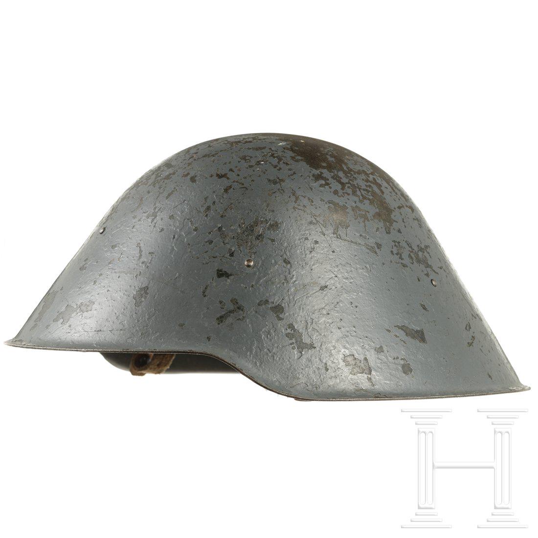 A steel helmet M 56 in special design, 1960s: A steel helmet M 56 in special design, 1960sStahl, in zwei Schichten zeitgenÃ¶ssisch blaugrau lackiert (stark berieben, kleine Dellen). Komplett mit Lederfutter und Kinnriemen. UngewÃ¶hnlich sind 