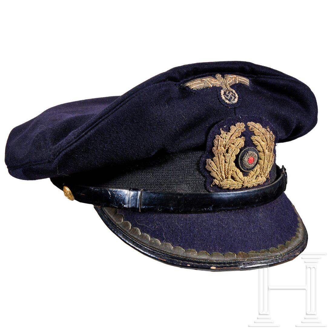 A visor cap for Officers of the Kriegsmarine: A visor cap for Officers of the KriegsmarineDark blue, non-removable cloth top, black mohair centre band, black leather chinstrap retained by gold buttons. Cloth covered visor obverse with finely embr