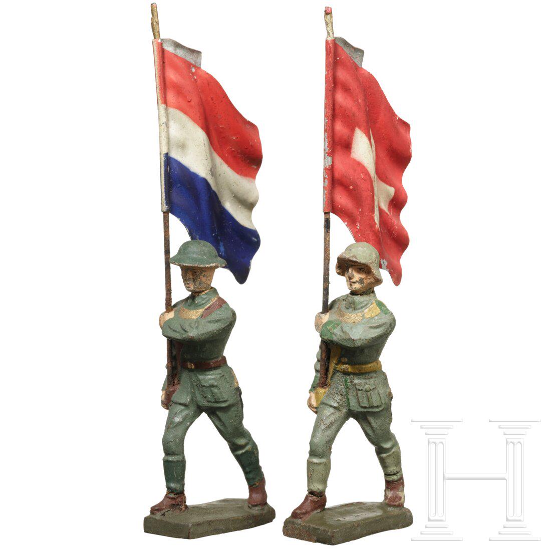 A Dutch and a Swiss Lineol flagbearer marching: A Dutch and a Swiss Lineol flagbearer marchingZwei Lineol-Fahnenträger, Masse-Blechausführung, 30er Jahre, 7 cm-Serie, jeweils mit der originalen, spritzlackierten Lineol-Fahne von Holland u