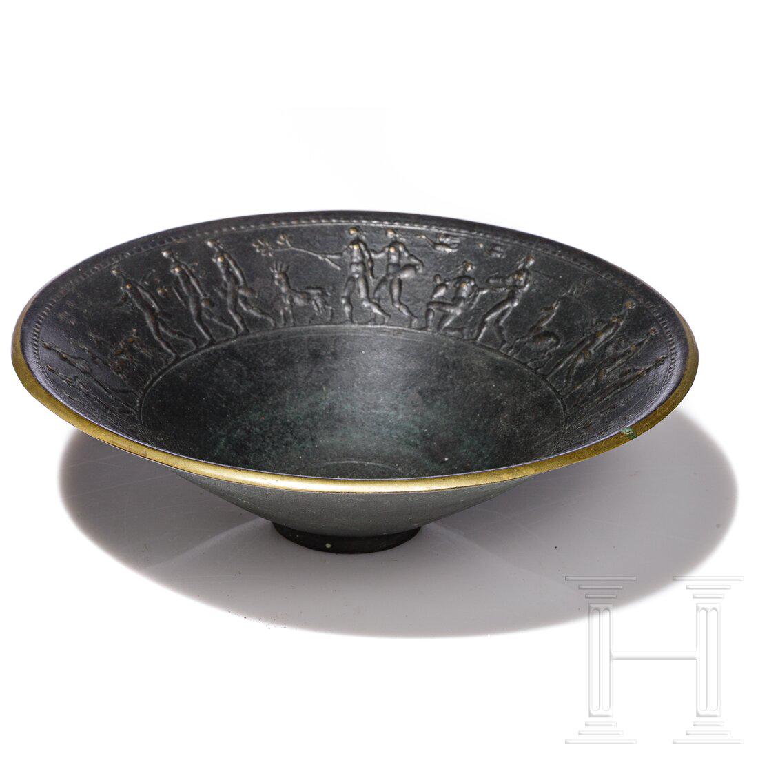 A German bronze bowl in antique style, 20th century: A German bronze bowl in antique style, 20th centuryBronze, patiniert. Tiefe Schale mit schräger Wandung auf kleinem Stand. Auf der Innenseite umlaufender Relieffries mit Darstellung eines Festzug