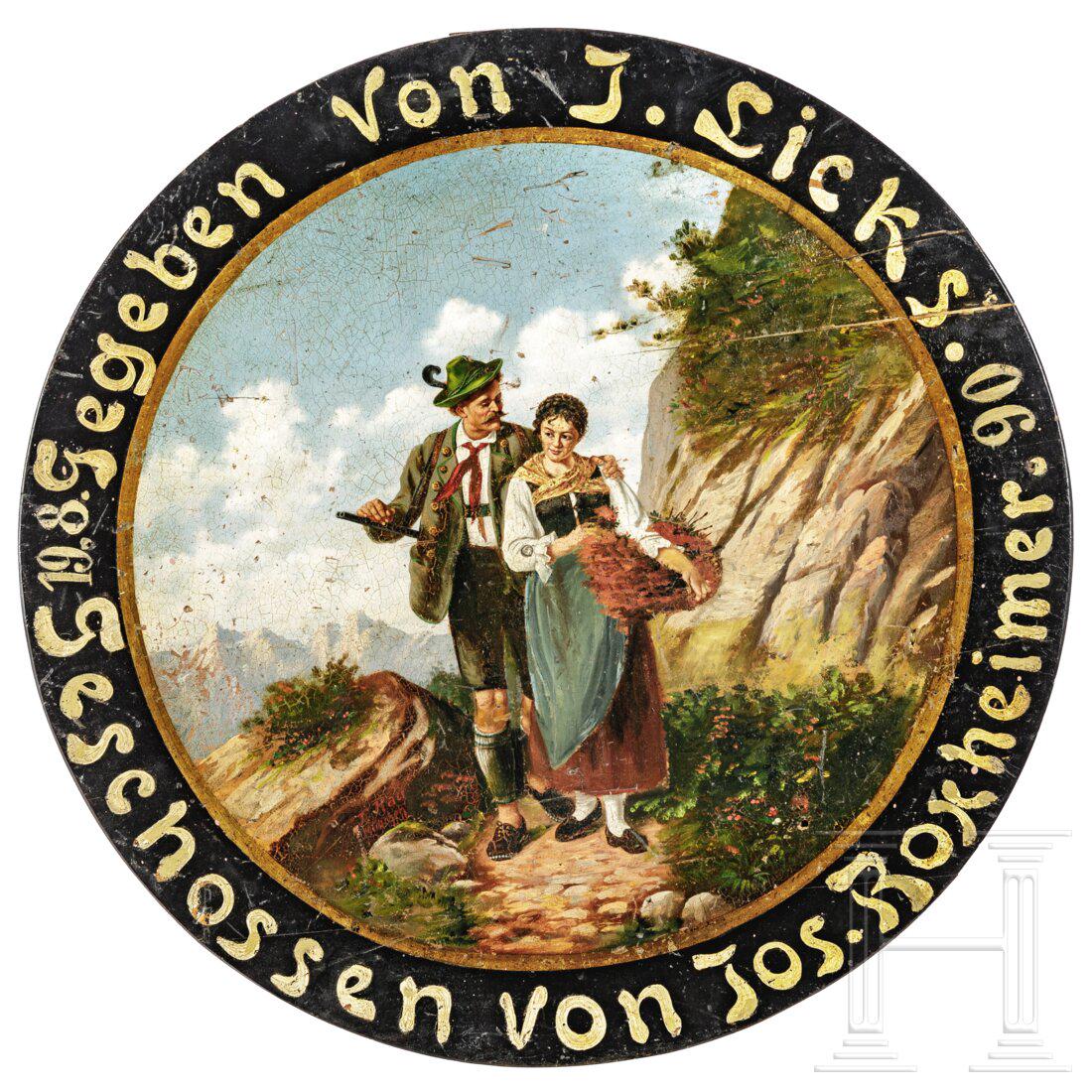 A German shooting target, 1906: A German shooting target, 1906Öl auf Holz. Darstellung eines in Volkstracht gekleideten Paares auf einem Bergwanderweg. Auf dem Felsen links "J. Rau. München" signiert. Auf der ebonisierten 