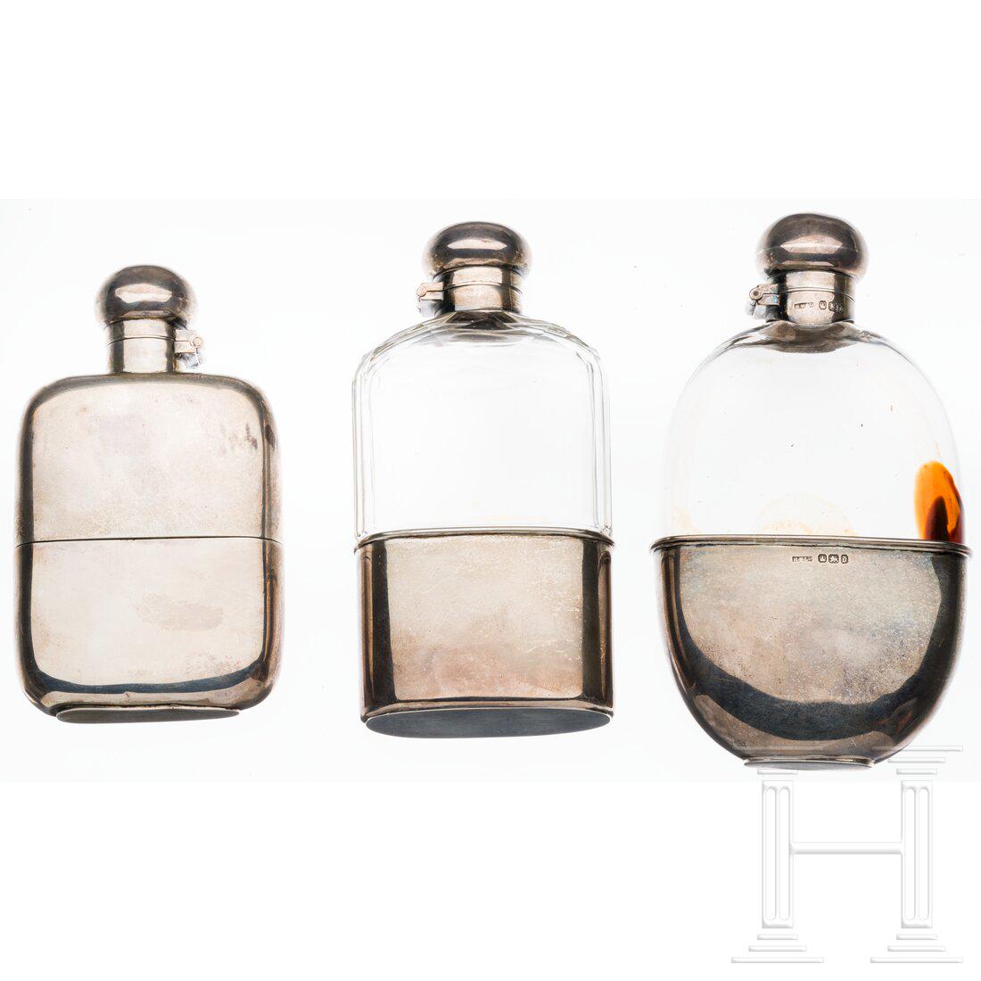 Three English hip flasks, 19th/20th century: Three English hip flasks, 19th/20th centuryZwei silbergefasste Glasflaschen, dazu eine ganz aus Silber gefertigte, jeweils mit Bajonettverschluss und mit zahlreichen Silberpunzen versehen. Höhe 1