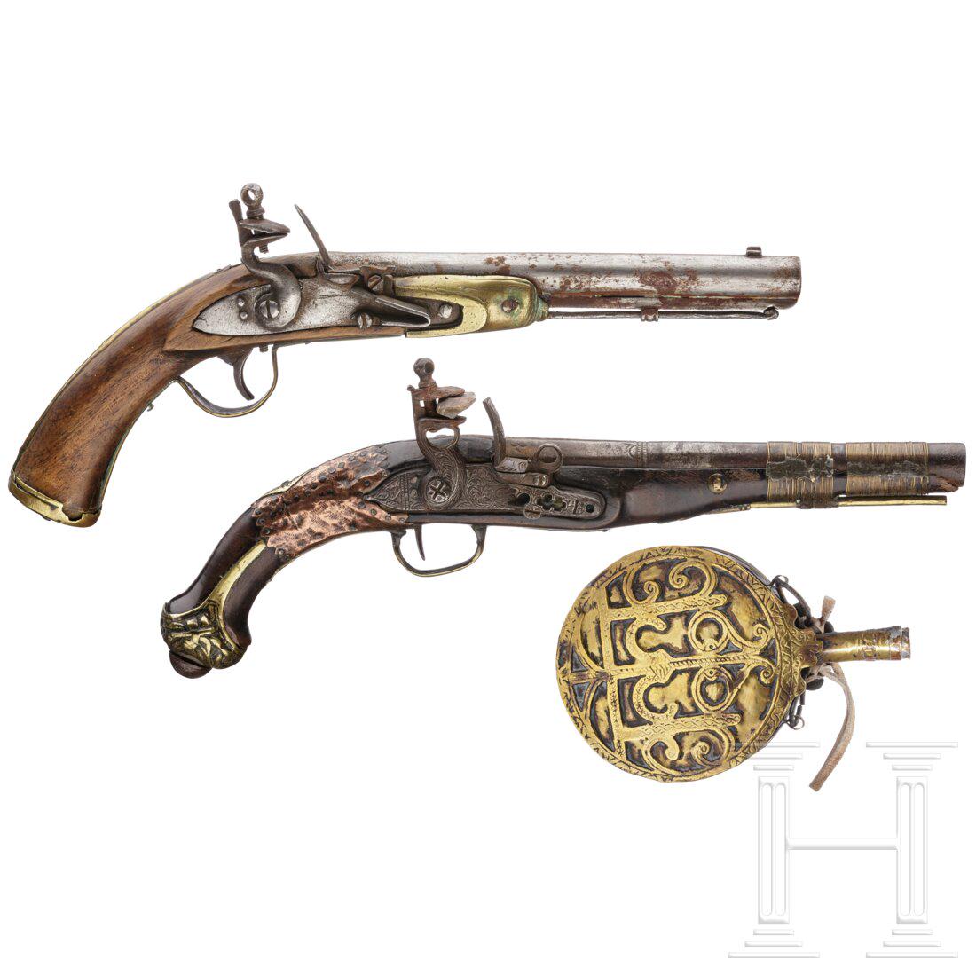 Two Moroccan flintlock pistols and a powder flask,: Two Moroccan flintlock pistols and a powder flask, 19th./20th century Glatte Läufe im Kaliber 16 mm, Steinschlösser (Schlossgang jeweils hakelig). Eine Pistole halb-, die andere vollgesch