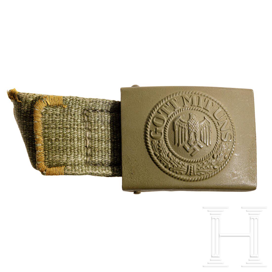 An Afrikakorps tropical belt buckle: An Afrikakorps tropical belt buckleEisenblech, grün lackiert, nach rechts blickender Adler. Angenähte Lasche aus Webleinen (Breite 35 mm), die Enden zus. vernäht. Kein Hersteller, innen leichte Alt