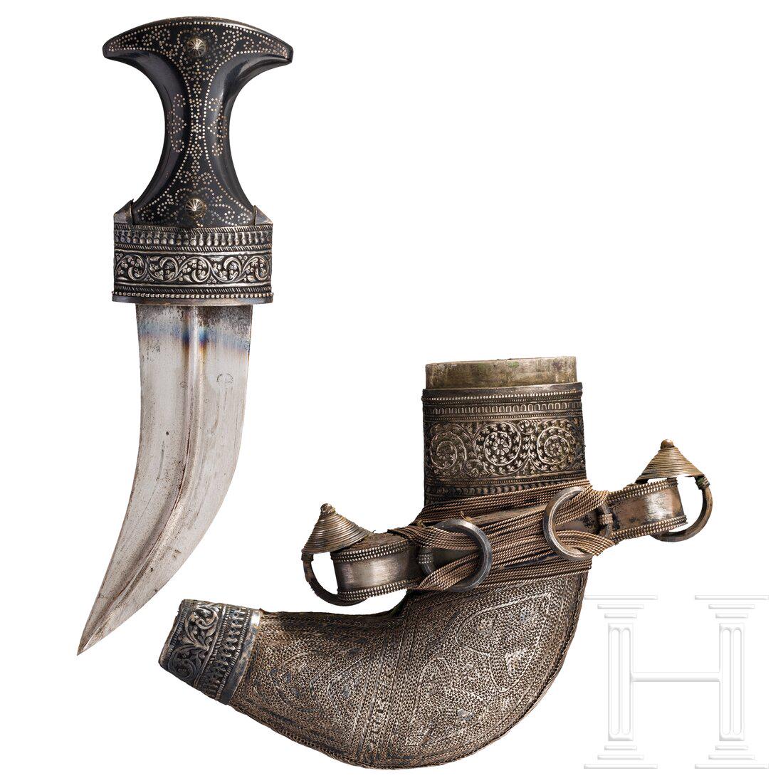 A Yemen silver mounted djambia, 20th century: A Yemen silver mounted djambia, 20th century Gekrümmte, zweischneidige, beidseitig gegratete Stahlklinge. Schauseitig und am Knauf fein mit Silberstiften eingelegter Horngriff mit unterseitig flo