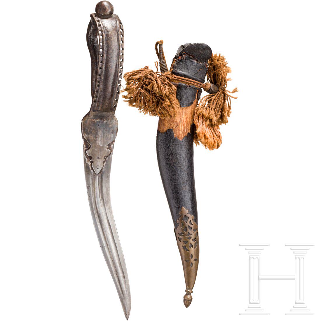 An Indian bichawa, 19th century: An Indian bichawa, 19th century Geschwungene, beidseitig doppelt gekehlte, zweischneidige Stahlklinge mit vernietetem Eisengriff in Bügelform. Fragmentarisch lederbezogene Holzscheide mit Ortbesc