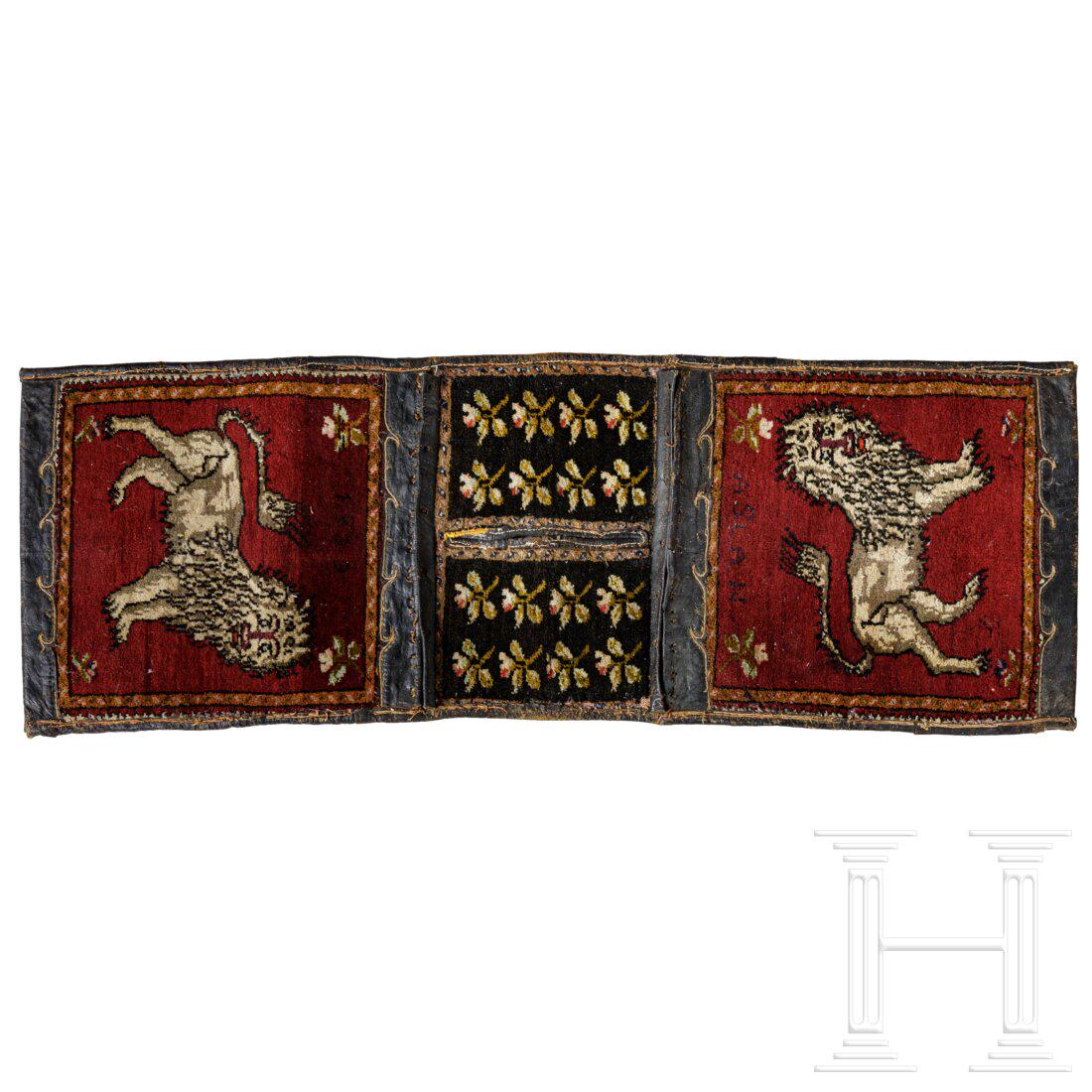 A Tibetan saddle blanket with snow lion motive, dated 1939: A Tibetan saddle blanket with snow lion motive, dated 1939 Mehrteilig gearbeitete Auflage aus geknüpften Teppichteilen mit Einfassung aus dunklem Leder. Beidseitig das Motiv eines stehenden Schne