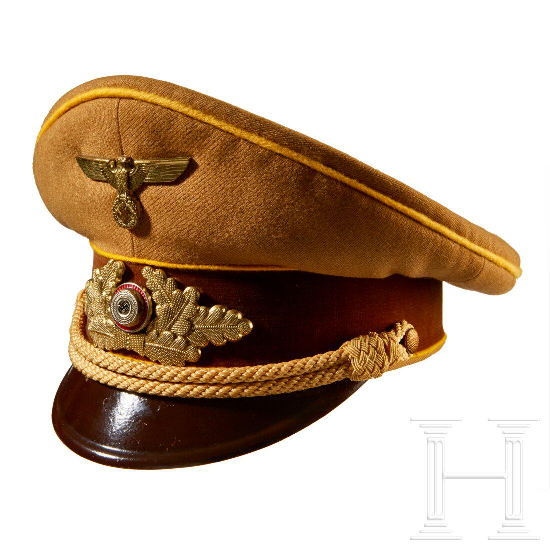 A Visor Cap for NSDAP Leaders in the Reichsleitung: A Visor Cap for NSDAP Leaders in the Reichsleitung Tan tricot, brown velvet center band, yellow wool piping, gold celleon braided chin cords, retained by pebbled button attachment. Dark brown lacquere