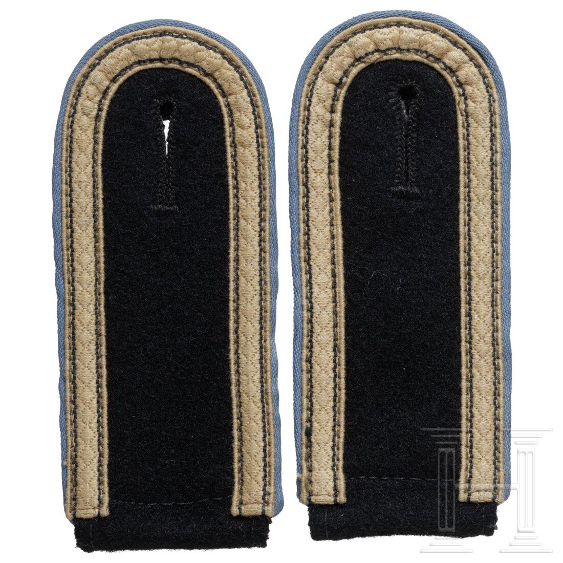 A pair of shoulder boards for the tropical uniform of an UnterscharfÃ¼hrer of the SS supply units: A pair of shoulder boards for the tropical uniform of an UnterscharfÃ¼hrer of the SS supply unitsZum Aufschlaufen aus schwarzem Abzeichentuch mit hellblauen VorstÃ¶ÃŸen, sandfarbener Ranglitze u