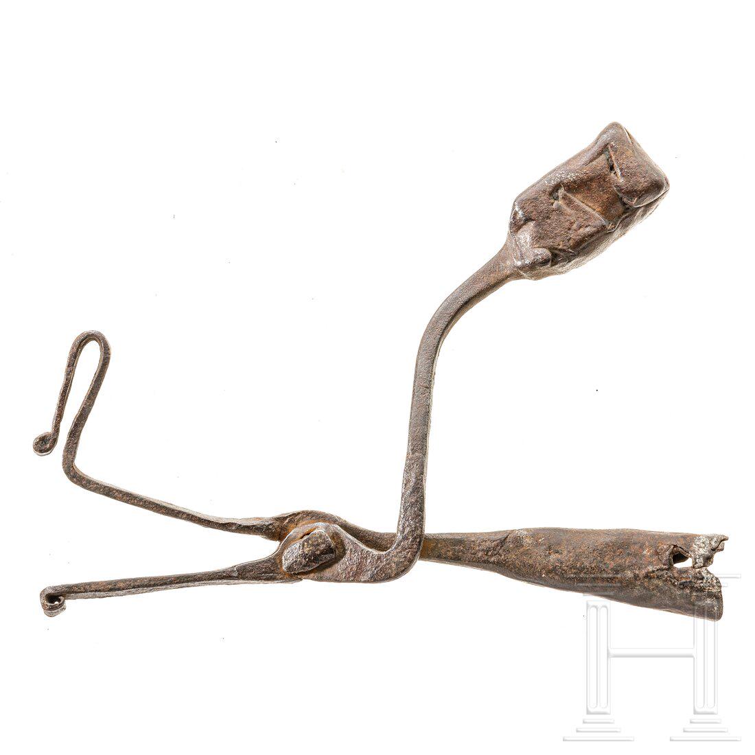 A German pinewood chip holder, 17th/18th century: A German pinewood chip holder, 17th/18th centurySchmiedeeisen. ZangenfÃ¶rmiger Kienspanhalter mit seitlicher Stockvorrichtung und rechteckigem Gegengewicht. Leicht konische TÃ¼lle mit zwei Befesti