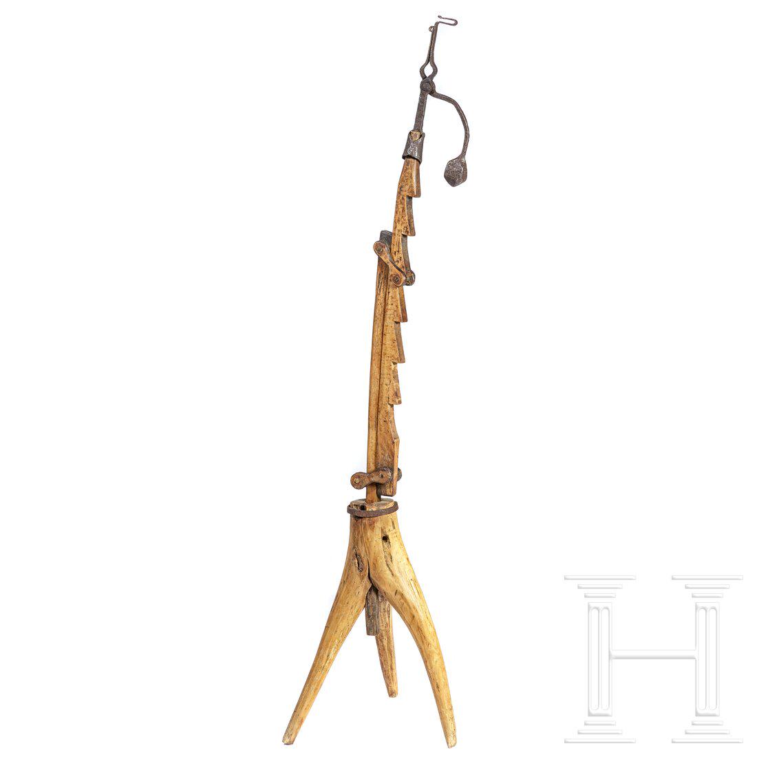 A large German pinewood chip holder with stand, 17th/18th century: A large German pinewood chip holder with stand, 17th/18th centuryDreibeiniger Holzfuss. Langgezogener Holzkorpus mit Zargen. Montierung aus Eisen mit rundem Gegengewicht. Eisen mit Korrosionsspuren. G
