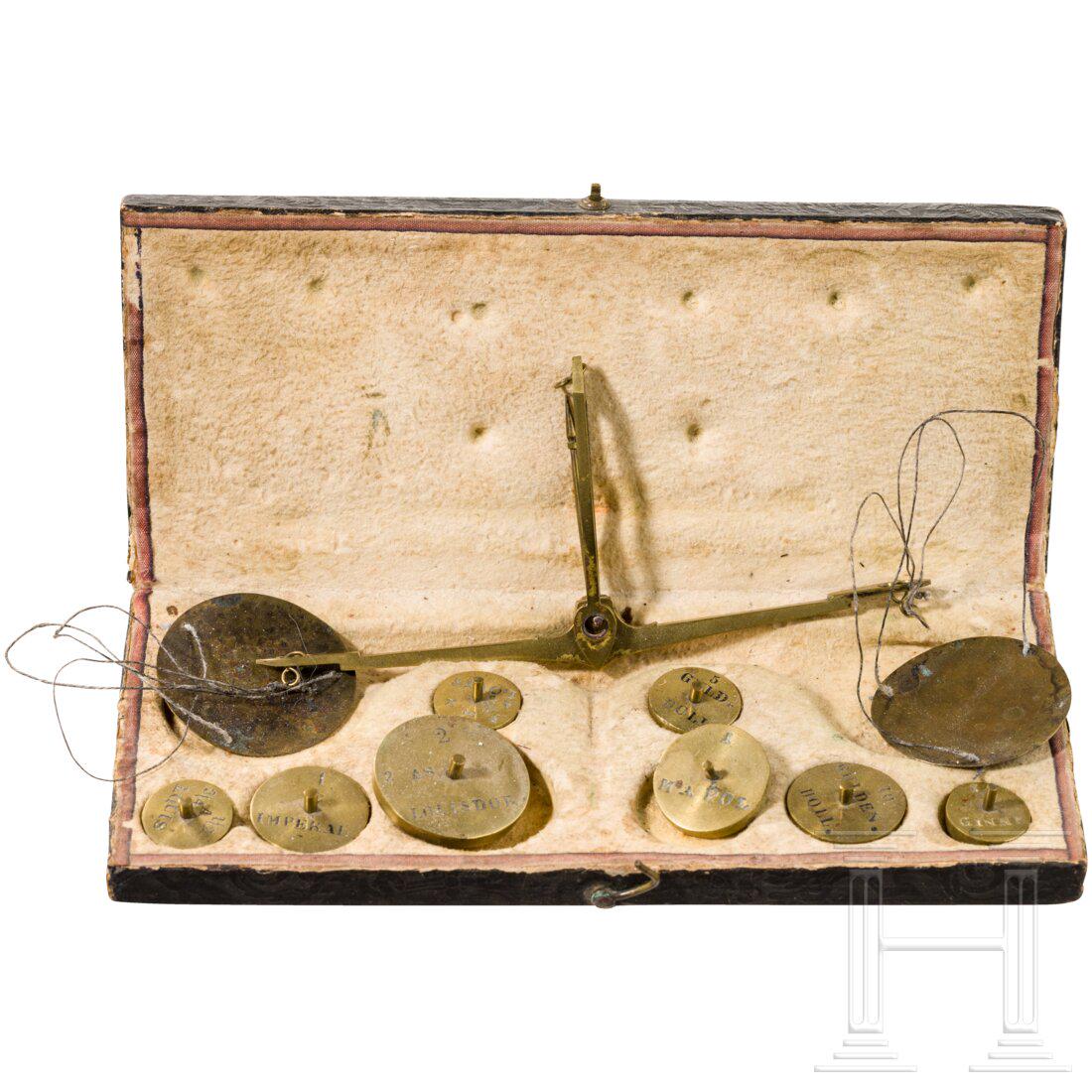 A French coin scale, circa 1800: A French coin scale, circa 1800Papierbezogener, floral geschmÃ¼ckter Deckelkasten. Das Innere mit weichem Leder ausgekleidet. Messing-Balkenwaage mit Messingschalen und insgesamt acht unterschiedlic