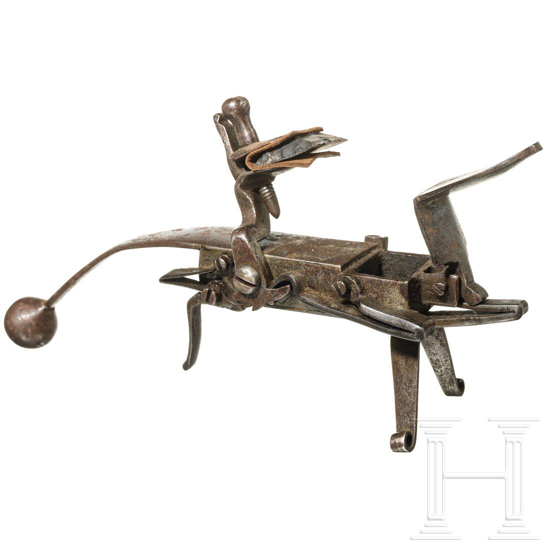 A German flintlock lighter, ca. 1700: A German flintlock lighter, ca. 1700Eiserner Rahmen mit seitlichem Hahn, zweibeinigem StandfuÃŸ und kugeligem Griffknauf sowie linksseitigem Abzug und Hahn (Batteriefeder schwach). An der linken Sei