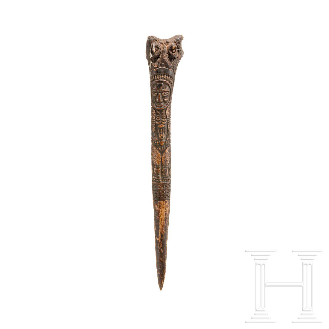 A Papua New Guinean carved bone dagger, 19th century: A Papua New Guinean carved bone dagger, 19th centuryAus dem Oberschenkelknochen eines Kasuars geschnitzter Dolch mit Alterspatina. Schauseitig figÃ¼rlich beschnitzt. LÃ¤nge ca. 31 cm. Condition: I