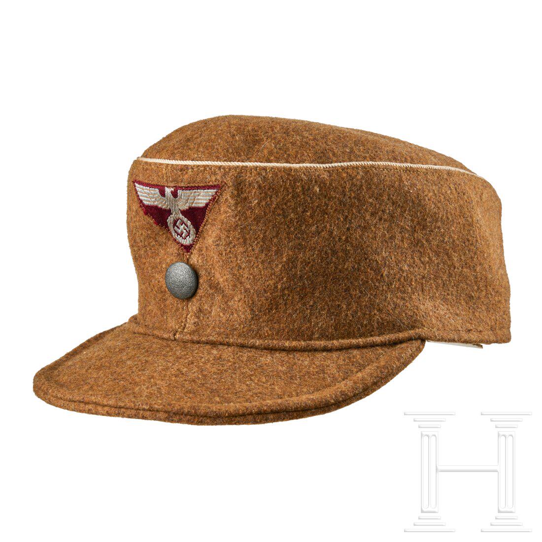 A Field Cap for SA Other Ranks: A Field Cap for SA Other RanksCap body in brown wool, piped in white celleon twist cord, machine-woven silver-aluminum wire eagle on a wine-red trapezoid, machine-applied above a grey finish pebbled b