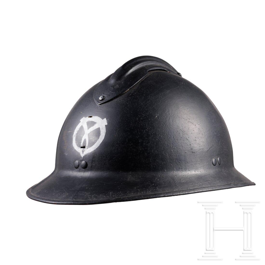 A steel helmet M 26 Adrian with Vichy emblem, 1940 - 1944: A steel helmet M 26 Adrian with Vichy emblem, 1940 - 1944Stahl (narbig), dunkelgrau nachlackiert (berieben), stirnseitig silbern aufgemaltes Emblem der Miliz des Vichy-Regimes. Gelaschtes schwarzes Fu
