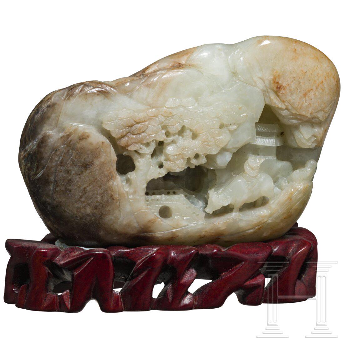 A Chinese jade carving, 20th century: A Chinese jade carving, 20th centuryGrÃ¼n-braune Jade. Block-Jadeit mit fein geschnitzter Siedlung in den Bergen. Im Vordergrund Ã¼berquert ein einen Ochsen reitender FlÃ¶tenspieler eine BrÃ¼c