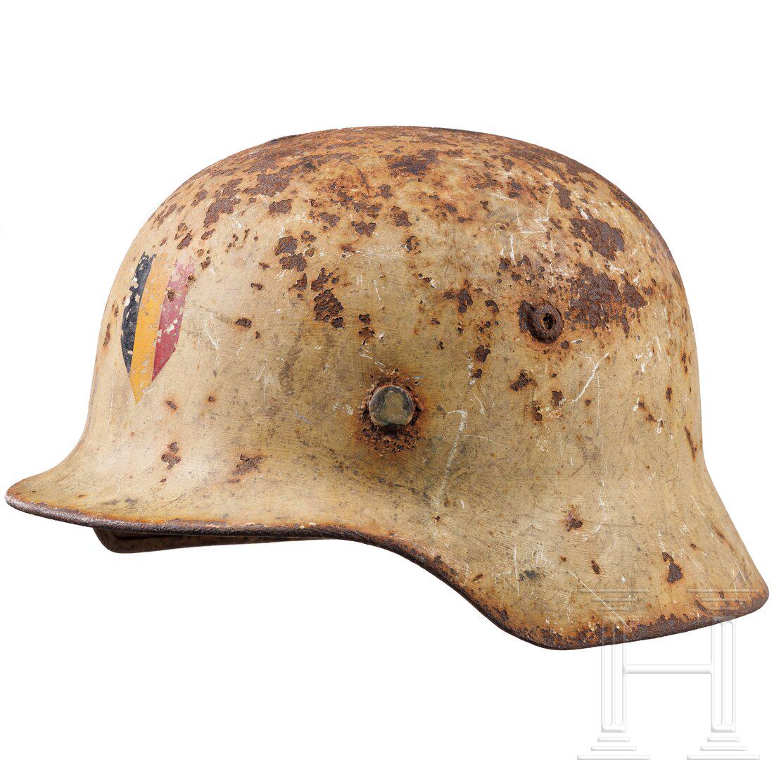 A German steel helmet M 35 with winter camouflage painting and Belgian emblem: A German steel helmet M 35 with winter camouflage painting and Belgian emblemStahlglocke mit BelÃ¼ftungsnieten, rostig/narbig mit weiÃŸem Anstrich, stirnseitig auflackierte belgische Flagge, kompl