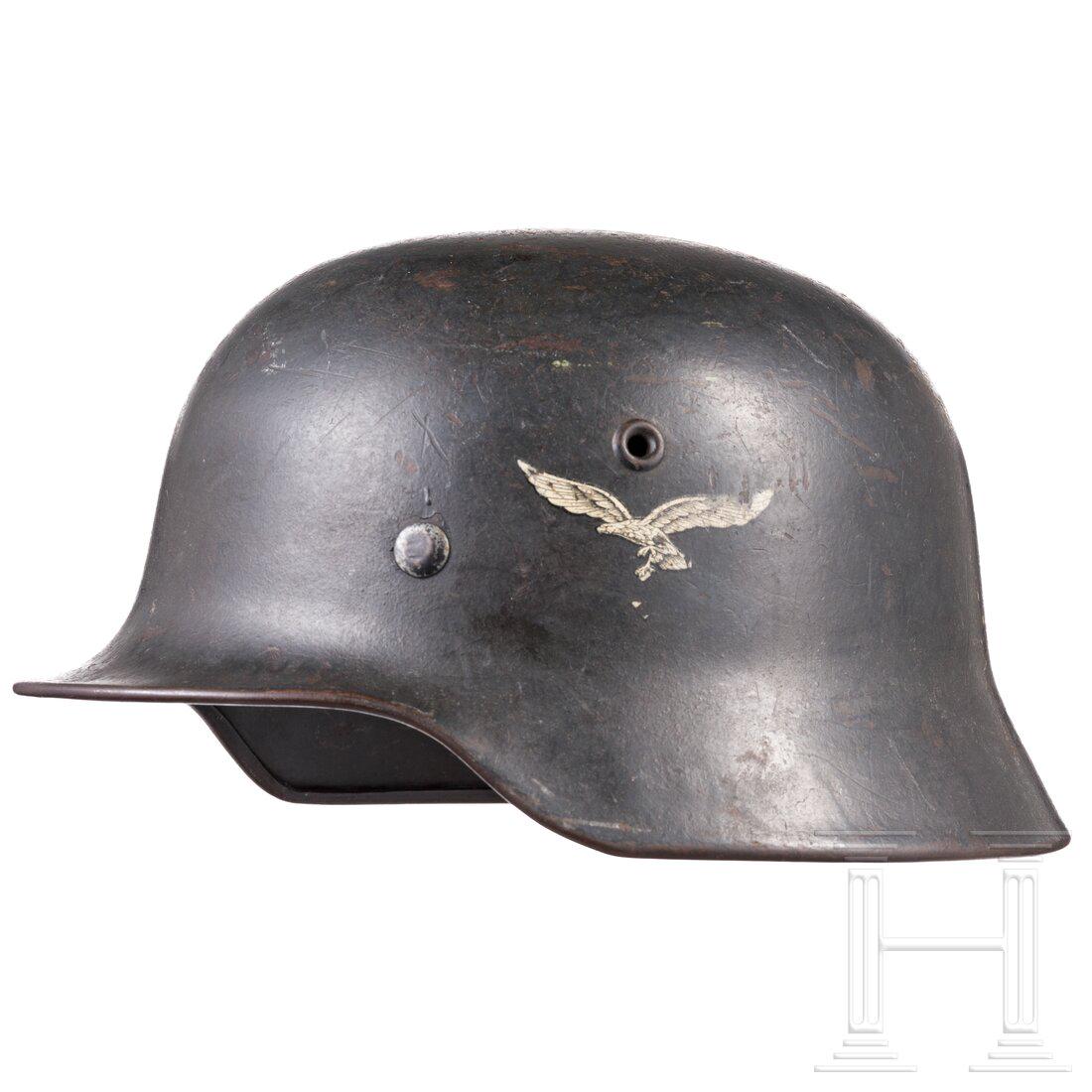 An air force steel helmet M 40 with remains of the eagle decal: An air force steel helmet M 40 with remains of the eagle decalDie Glocke mit mitgeprÃ¤gten BelÃ¼ftungsnieten und luftwaffenblauer Lackierung (verputzt, konserviert), das Hakenkreuz des Adlerabzeic