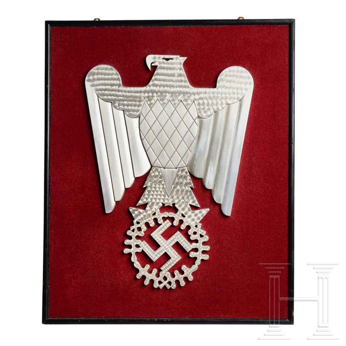 A Wall Eagle: A Wall EagleSilver art deco style cut-metal eagle with folded wings, multi-piece construction, mounted to a red felt covered wooden base by threaded screws, a black frame around the outer borders, two