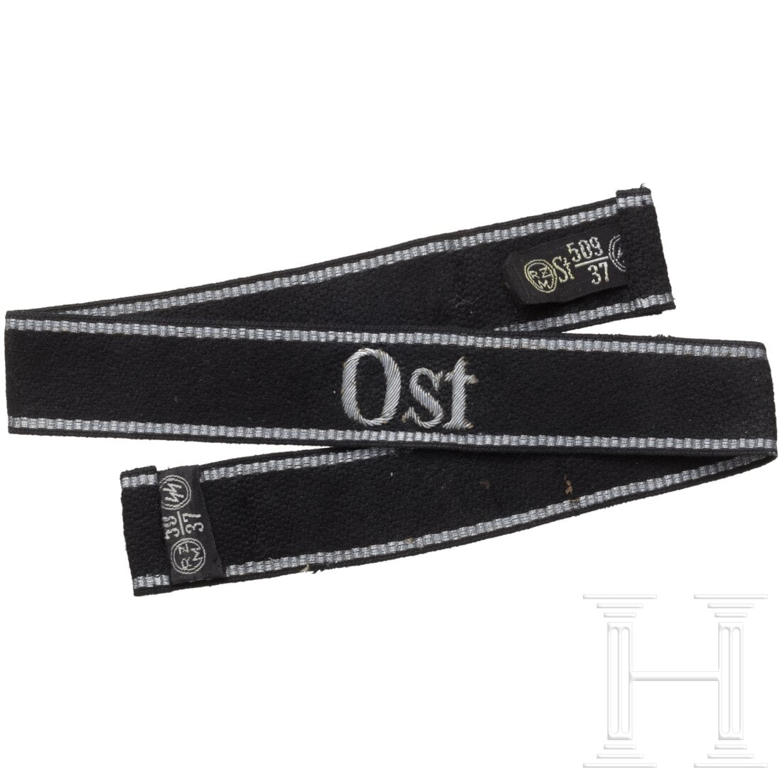 A cuff title for officers in the staff of SS-district "Ost": A cuff title for officers in the staff of SS-district "Ost"Schwarz gewebtes Band (kleine Aufrauhungen) in RZM-Ausführung mit silbern eingestickter lateinischer Aufschrift "Ost" und eingewebten silber