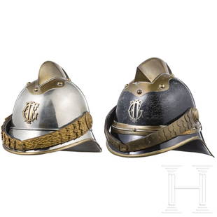 Two fire fighter helmets, most likely Austrian, circa 1900: Two fire fighter helmets, most likely Austrian, circa 1900Ein Mannschaftshelm mit schwarz lackiertem Blechkorpus (krakeliert) und Messingbeschlägen, stirnseitig aufgelegt ein Metall-Emblem, gebildet