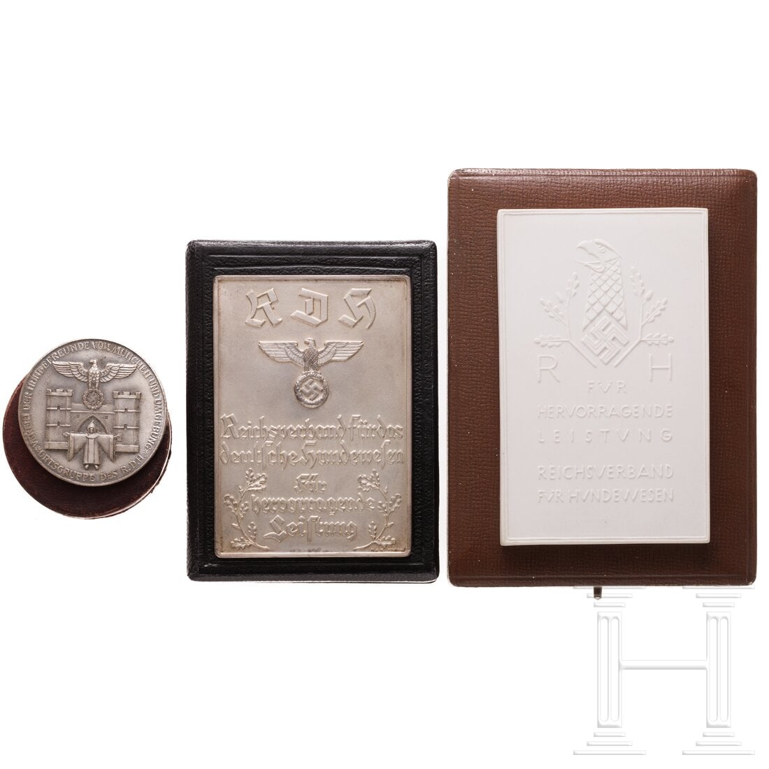 Three cased plaques from the Reich Association for the German Dog Club (RDH): Three cased plaques from the Reich Association for the German Dog Club (RDH)Jeweils im Verleihungsetui: eine rechteckige, versilberte Plakette und eine aus weißem Böttgerporzellan "Für hervorragend