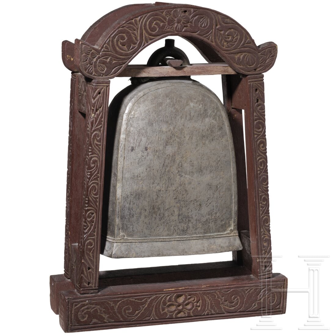 A Tibetan bell, 19th century: A Tibetan bell, 19th centuryRechteckige, oben halbrunde Form mit kräftiger Krone und umlaufendem Zierband am unteren Rand. Innen hölzerner, stoffumwickelter Klöppel. Reich floral beschnitztes, boge