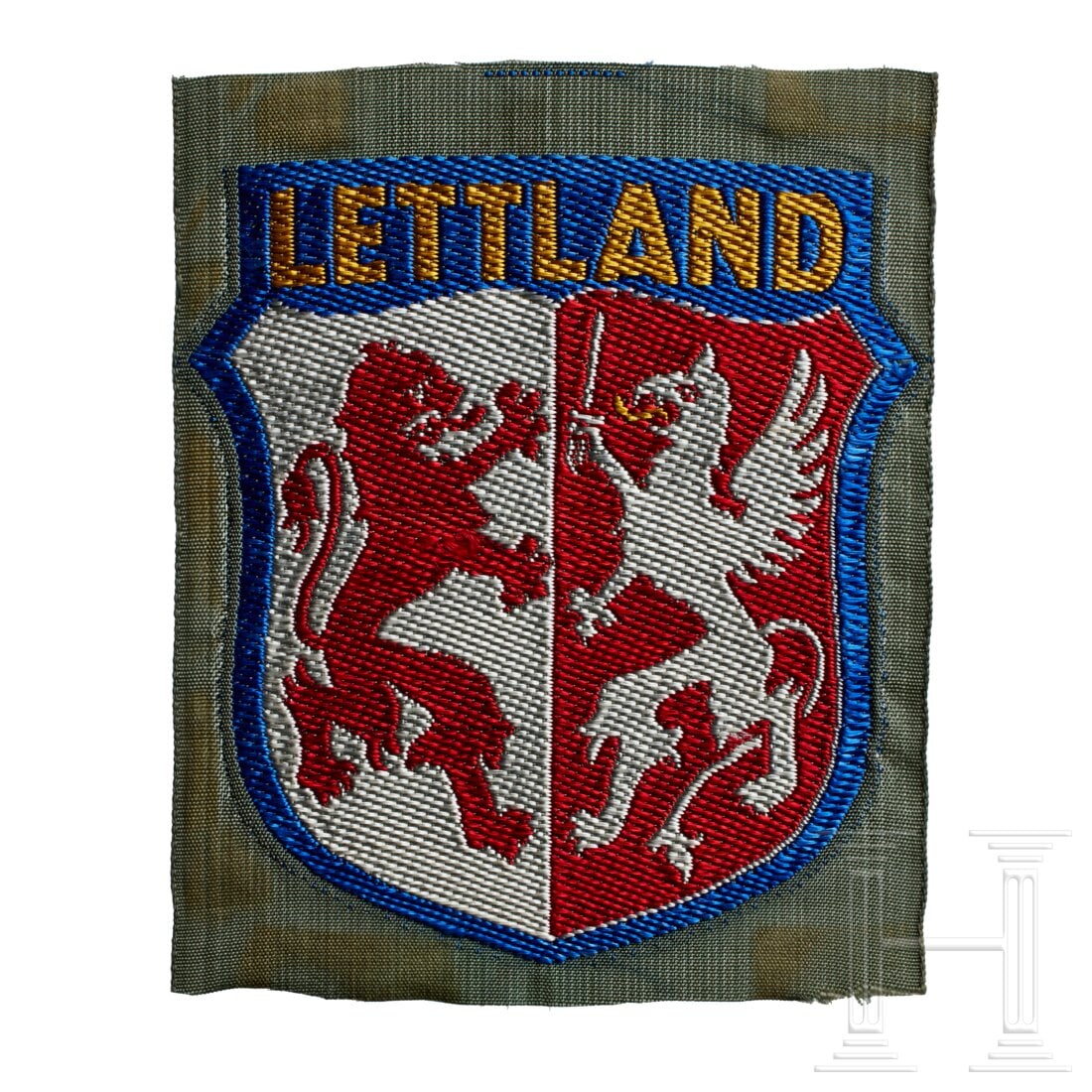 An Arm Shield for Latvian Volunteers: An Arm Shield for Latvian VolunteersField-grey rayon base, machine-woven blue/white/red shield, red lion and white griffon at centre, yellow lettering in banner at top "LETTLAND".USA lot - more info h