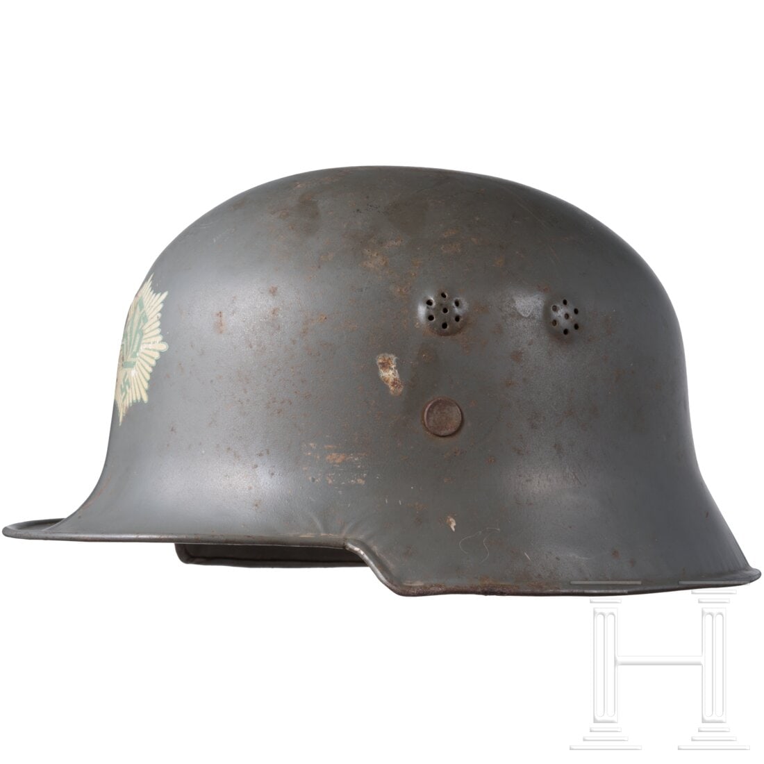 A steel helmet M34: A steel helmet M34Feldgraue Lackierung, vorne das RLB-Helmwappen, ca. 97 % erhalten, an der Seite ein kleines Loch und etwas verbeult, komplett mit Innenfutter und Kinnriemen, dieser an einer Stelle g
