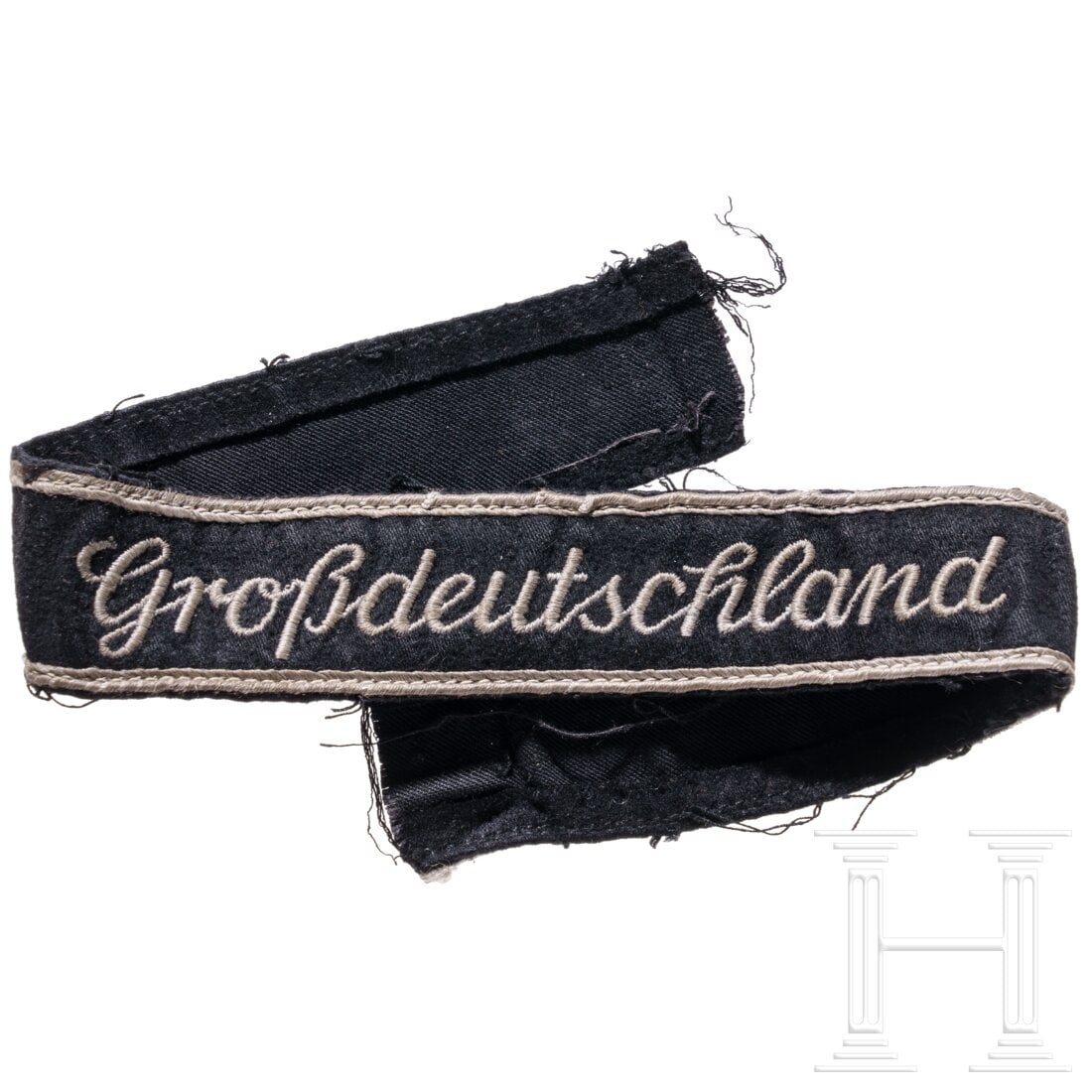 A "Großdeutschland" cuff title for EM/NCOs: A "Großdeutschland" cuff title for EM/NCOsSchwarzes Ärmelband mit mattgrauen Randlitzen und maschinengesticktem Namenszug in lateinischer Schreibschrift (letztes Modell). Getragen, mit Fehlstellen, 