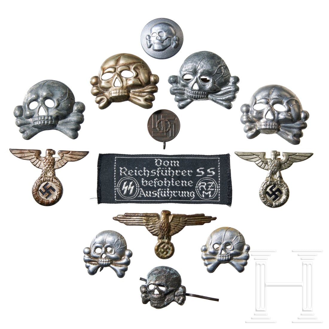 A Small Collection of SS Insignia: A Small Collection of SS InsigniaFour early style 1923 jawless visor cap skulls, stamped silver metal, attachment pins intact. Two small jawless skulls for panzer collar tab, stamped silver metal, rou