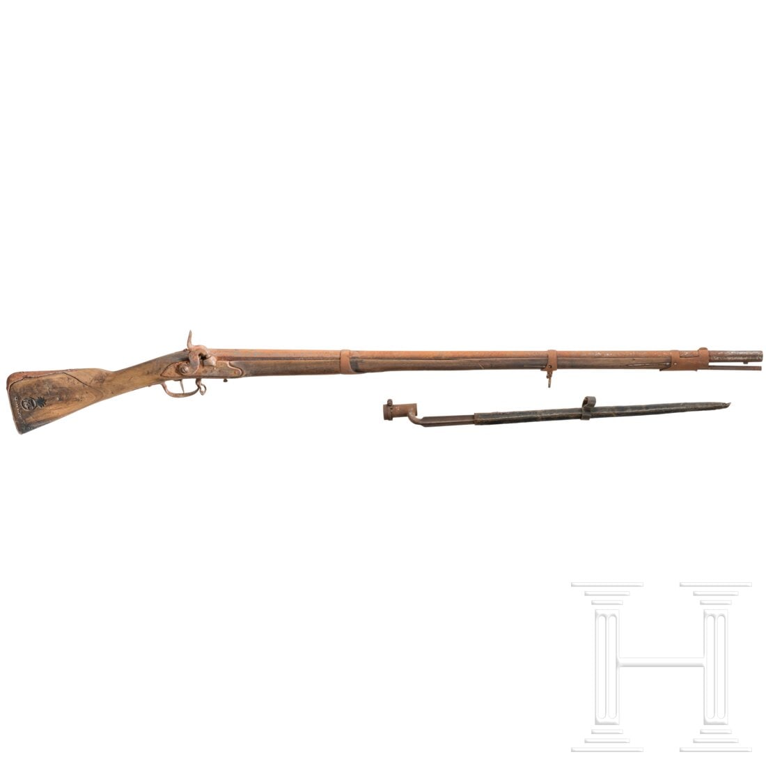 A Fortschau Musket: A Fortschau MusketSteinschloss auf Perkussion aptiert. Von oktagonal in rund übergehender Lauf. Schlossblech ohne Bestempelung. Vollschaft mit Eisengarnitur. Rechts im Kolben guter Eigentumsstempel. 