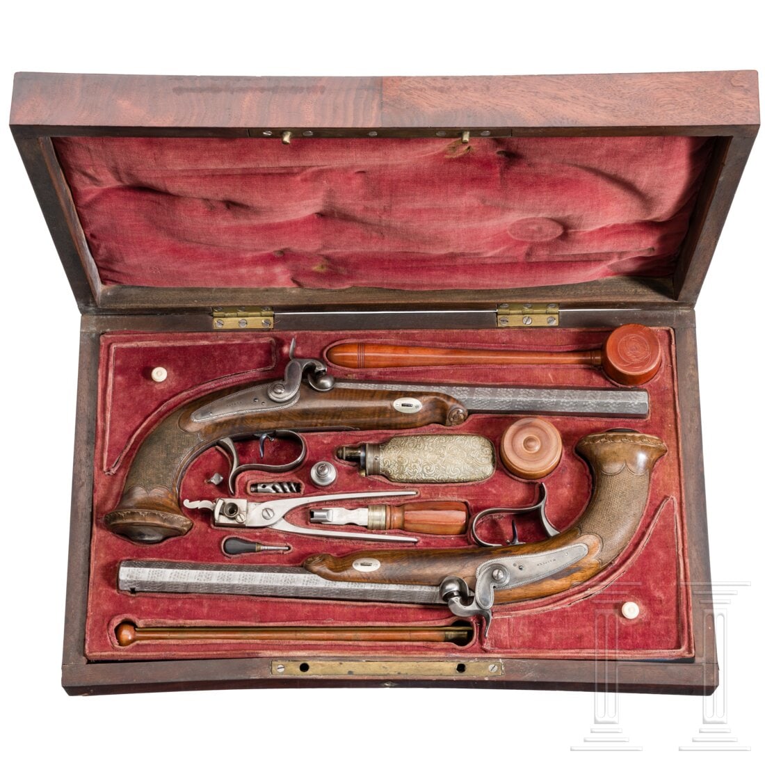 A pair of Swiss or Italian percussion pistols in a case, circa 1850: A pair of Swiss or Italian percussion pistols in a case, circa 1850Oktagonale Läufe aus Rosen-Banddamast mit gezahnter Seele im Kaliber 12 mm. Jeweils auf der Oberseite in mit Silbertauschierung umra