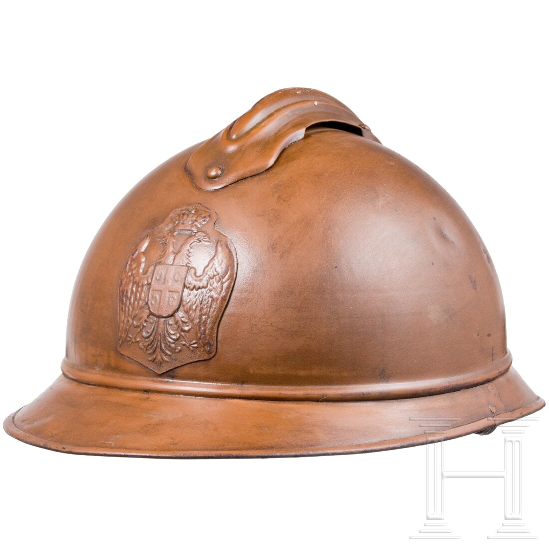 A Serbian steel helmet M 15 "Adrian", 1915 - 1918: A Serbian steel helmet M 15 "Adrian", 1915 - 1918In ockerfarbenem Ton lackierte Stahlglocke (berieben, Rostspuren, kleine Dellen, Spuren von Klarlack) mit aufgesplintetem eisernen Emblem des Königrei
