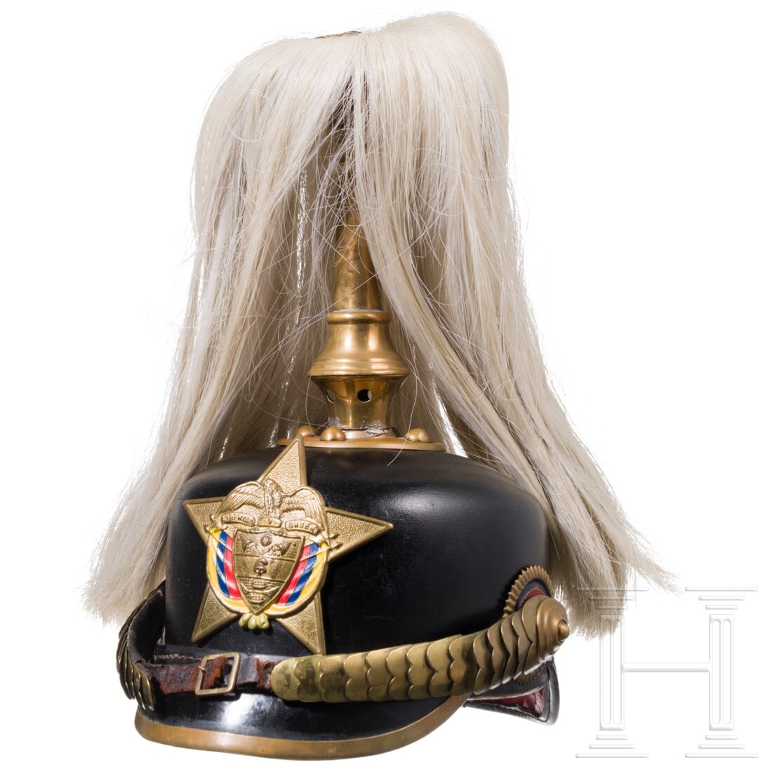 Colombia - a helmet for members of the Colombian army, circa 1930: Colombia - a helmet for members of the Colombian army, circa 1930Schön erhaltene schwarz lackierte Lederglocke mit Buntmetallbeschlägen. Stirnseitig verschraubt ein geprägter fünfstrahliger Stern 