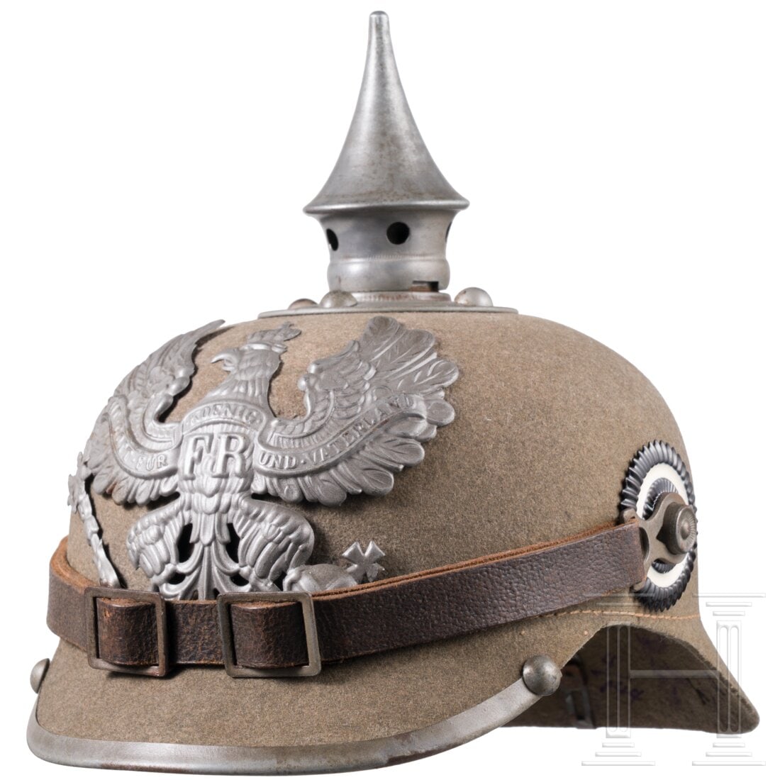 A felt helmet for enlisted men of the infantry, circa 1915: A felt helmet for enlisted men of the infantry, circa 1915Korpus aus feldgrauem Filz, graue Eisenbeschläge. Stirnseitig das preußische Adleremblem, durch Lederkeile fixiert. Teller mit vier Rundkopf