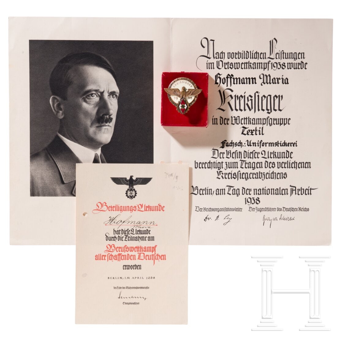 A cased 1938 Kreissieger Badge with award certificate: A cased 1938 Kreissieger Badge with award certificateBuntmetall, bronziert und emailliert, Hersteller "G. Brehmer Markneukirchen", im originalen roten Etui, auf der Unterseite des Etuis der Name der