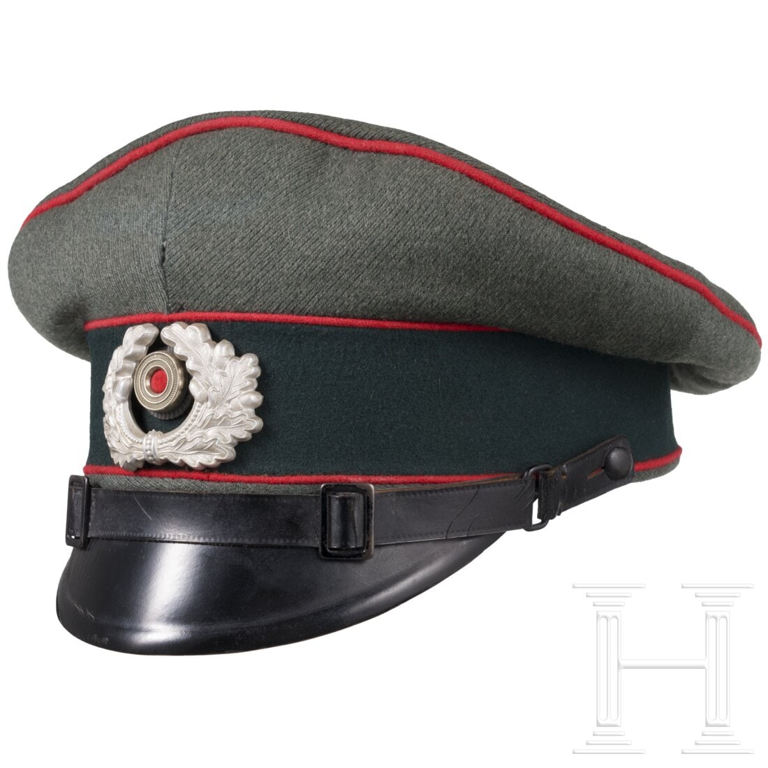 A visor cap for EM/NCO's of the artillery: A visor cap for EM/NCO's of the artilleryEigentumsstück aus feldgrauem Gabardine mit dunkelgrünem Besatzstreifen und roten Vorstößen. Bräunliches Wachstuchfutter mit beschädigtem Mützentrapez, 