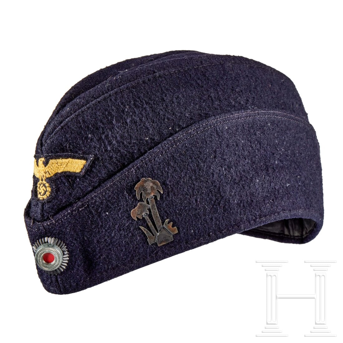 A Field Cap for Kriegsmarine Enlisted: A Field Cap for Kriegsmarine EnlistedCap body of dark-blue wool, boat-shaped, machine-embroidered eagle on dark-blue backing, hand-applied, metal cockade pinned to front, brass “palm tree” ins